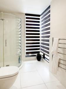 a bathroom with a toilet and a shower and a window at Mt Maunganui Main Beach Luxury with Seaviews in Tauranga