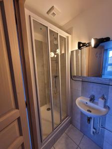 een badkamer met een douche en een wastafel bij LE RELAIS VAUBAN 