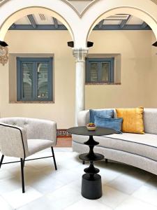a living room with a couch and a table and chairs at Itaca Sevilla by Soho Boutique in Seville