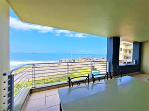 a balcony with two benches and a view of the ocean at La Mer C in Margate