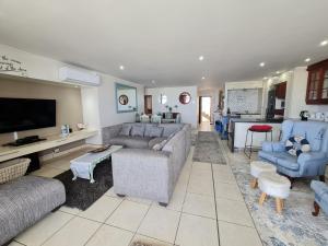 uma sala de estar com sofás e cadeiras e uma televisão em La Mer C em Margate