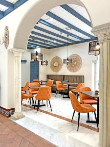 ein Esszimmer mit orangefarbenen Stühlen und Tischen in der Unterkunft Itaca Sevilla by Soho Boutique in Sevilla