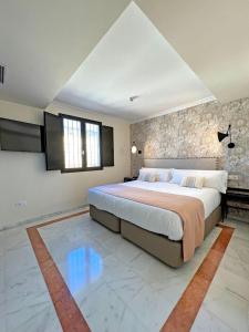 ein Schlafzimmer mit einem großen Bett und einer Steinmauer in der Unterkunft Itaca Sevilla by Soho Boutique in Sevilla