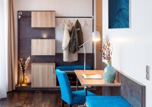 a dining room with a table and blue chairs at KONCEPT HOTEL Benedikt vormals H2O in Siegburg
