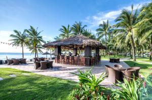 a gazebo on the beach with palm trees at Vinpearl Resort & Spa Phu Quoc in Phú Quốc