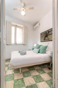a bedroom with a large bed with white sheets and green pillows at BIG FLAT IN CITY CENTER, UP To 12 PEOPLE in Málaga