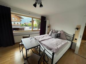 una camera da letto con un letto, un tavolo e una finestra di Haus am Bach a Erl