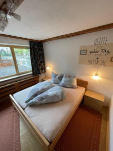 a bedroom with a bed with a sign on the wall at Haus am Bach in Erl