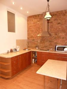 a kitchen with wooden cabinets and a brick wall at RigaCenter apartment in Riga
