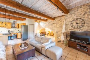 sala de estar con sofá y TV en Le Saint-Clémentois - Maison pour 6, en Saint-Clément