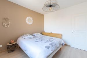 een slaapkamer met een bed en een kroonluchter bij Le Saint-Clémentois - Maison pour 6 in Saint-Clément