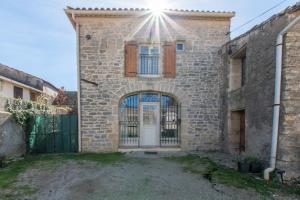 una casa de piedra con puerta y puerta en Le Saint-Clémentois - Maison pour 6, en Saint-Clément