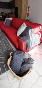 un sofá rojo con almohadas y una manta en el suelo en 2 Bedroom Apartment in San Gwann, en San Ġwann