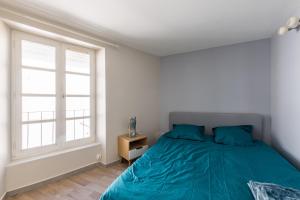 Un dormitorio con una cama verde y una ventana en La Tour - Appt climatisé pour 2, en Aubenas