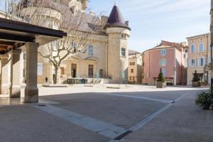 una calle vacía con un edificio con una torre en La Tour - Appt climatisé pour 2, en Aubenas