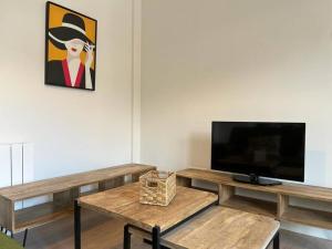 uma sala de estar com uma televisão de ecrã plano e uma mesa em Ático a estrenar Ribamontán-Mar em Hoznayo