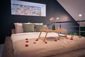 a bed with a table with roses on it at Maison avec jacuzzi privatif in Renac