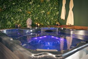 a jacuzzi tub with a statue in the background at Maison avec jacuzzi privatif in Renac