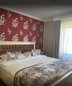 a bedroom with a large bed with a red wall at Vila Royal Mangalia in Mangalia