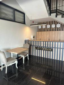 un ristorante con tavolo, sedie e orologi alle pareti di Akel Guest House a Tekirdağ