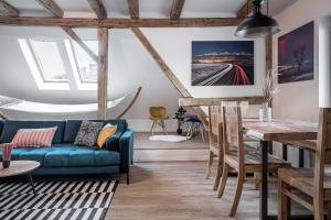 Una sala de estar con un sofá azul y una mesa. en Luxurious apartment in the heart of Poprad, en Poprad