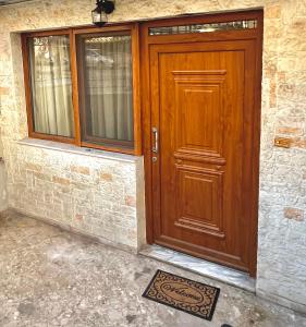 drewniane drzwi w kamiennym budynku z matą z przodu w obiekcie YOU Home apartment w Heraklionie