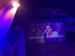 a tv in a dark room with a woman talking on the phone at Ingawale farmhouse (agro tourism) in Satara +133 photos