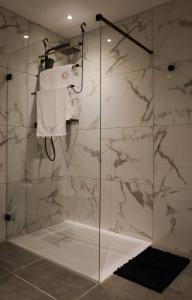 W łazience znajduje się przeszklony prysznic ze ścianami z białego marmuru. w obiekcie Large Seafront Maisonette w mieście St Paul's Bay