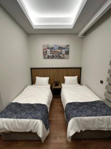 two twin beds in a room with at Akel Guest House in Tekirdağ