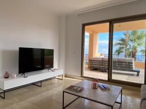 ein Wohnzimmer mit einem großen Flachbild-TV in der Unterkunft Elegant apartment, stunning views, fully renovated in la Hacienda del Senorio de Cifuentes in Estepona