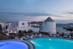 a view of a pool and the ocean at night at Porto Mykonos in Mikonos