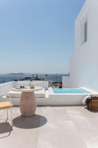 a patio with a table and a swimming pool at Porto Mykonos in Mýkonos City