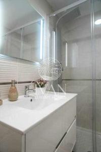 Baño blanco con lavabo y espejo en Casa CesarIVAN LUXURY HOMES 4ª Norte 1ª Línea, en El Borseral