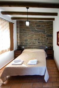 1 dormitorio con cama y pared de ladrillo en Complejo Rural El Recuerdo, 