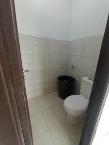 a bathroom with a toilet and a black trash can at RD Cottage Valley in Bogor