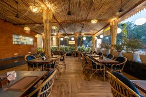 an empty restaurant with wooden tables and chairs at Le Seasons Resort in Candolim