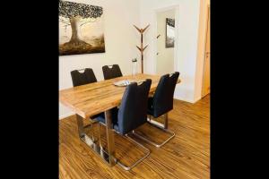 une salle à manger avec une table en bois et des chaises noires dans l'établissement Apartments La Rosa, à Rust