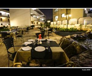 een eetkamer met tafels en stoelen en een rivier bij Hotel Trupti International HUBLI in Hubli