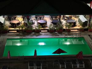 - une piscine avec des tables et des parasols dans l'établissement Prodiges Hôtel, à Yaoundé