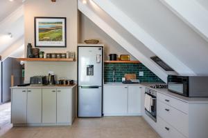 a kitchen with white cabinets and a refrigerator at Dornoch on Gowrie Farm, Nottingham Road in Nottingham Road