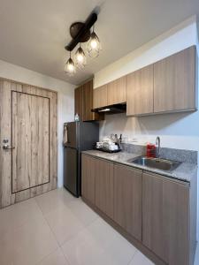 a kitchen with a sink and a refrigerator at INSPIRiA TOWER CONDOMINIUM 1126 in Davao City