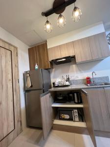 a kitchen with a stainless steel refrigerator and a sink at INSPIRiA TOWER CONDOMINIUM 1126 in Davao City
