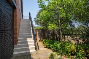 a staircase next to a brick building with a fence at Dornoch on Gowrie Farm, Nottingham Road in Nottingham Road