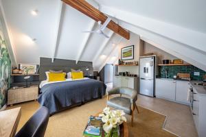a bedroom with a bed with yellow pillows and a kitchen at Dornoch on Gowrie Farm, Nottingham Road in Nottingham Road