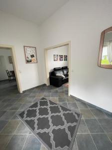 ein Wohnzimmer mit einem schwarzen Sofa und einem Teppich in der Unterkunft Ferienwohnung Majas in Adenau