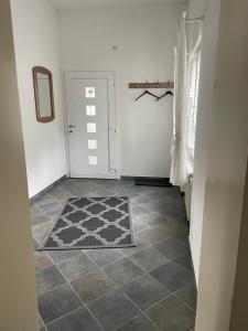 einen Flur mit Tür und Teppich auf Fliesenboden in der Unterkunft Ferienwohnung Majas in Adenau