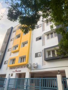 ein Gebäude in Gelb- und Weißtönen in der Unterkunft Richinn Palace home stay in Chennai