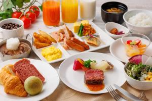 una mesa con platos de comida y bebida para el desayuno en Osaka Tokyu REI Hotel, en Osaka