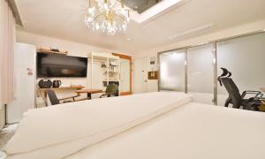 a bedroom with a large white bed with a chandelier at Daegu February Hotel DongdaeguStation in Daegu