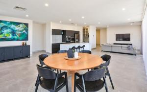 uma sala de jantar com uma mesa de madeira e cadeiras em Indulge Apartments - City View Penthouses em Mildura